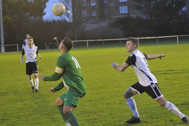 Bexhill United midfielder Jamie Bunn prepares to compete for an aerial ball